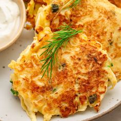 some food on a white plate with a bowl of ranch dressing in the back ground