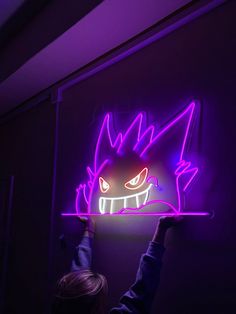 a person holding up a neon pokemon sign