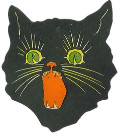 a black cat with green eyes and an orange hand painted on it's face