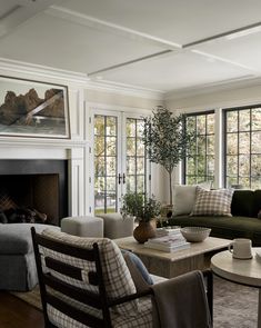 a living room filled with furniture and a fire place in front of a fireplace covered in windows