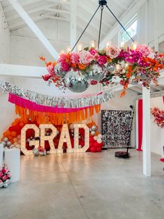 an arrangement of flowers and balloons decorates the entrance to a graduation party at grad