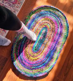 a person standing on the floor next to a multicolored rug