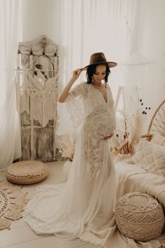 a woman in a white dress and hat standing next to a wicker basket on the floor