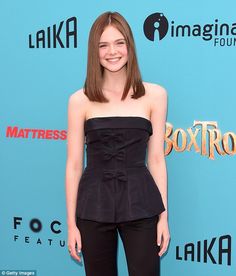 a woman in black pants and top posing for a photo on the red carpet at an event