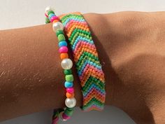 a close up of a person's arm wearing two bracelets with beads on it