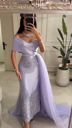 a woman taking a selfie in front of a mirror wearing a purple dress with silver sequins