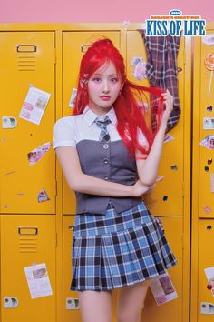 a girl with red hair is standing in front of lockers and posing for the camera