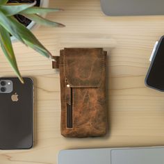 a cell phone and wallet sitting on top of a wooden table next to an iphone