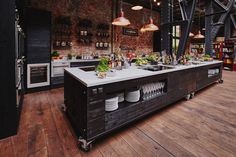 an industrial style kitchen with lots of counter space and lights hanging from the ceiling above it