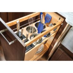 an open drawer with utensils and spoons in it on top of a wooden cabinet