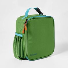 a green lunch bag with blue handles and zippers on the side, sitting against a white background