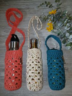 three crocheted water bottles sitting next to each other on top of a wooden table