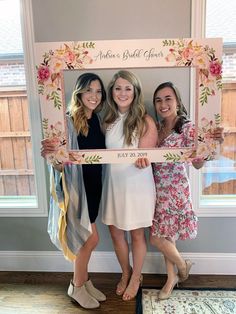 three women are holding up a photo frame with the words bride and groom written on it