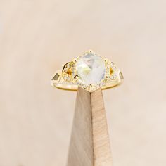 a diamond ring sitting on top of a wooden stand