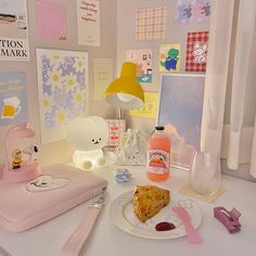 a white table topped with a slice of cake next to a lamp and other items