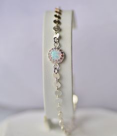 A sweet new bracelet made using a white lab created opal gemstone and sterling silver chain. The chain is made with 4mm discs that are connected with small links. The center of the bracelet features a single, 8mm round lab created opal set into a sterling silver crown edge setting. Bracelet closes with a sterling silver lobster clasp. Please choose desired length at checkout. Dainty and very on trend, perfect for any opal lover! ALSO available in gold or rose gold - please contact me for details Silver Opal Bracelet Gift, Adjustable White Opal Jewelry, Opal Bracelet Silver, October Gifts, Disc Bracelet, Silver Crown, Silver Sequin, Opal Bracelet, Opal Gemstone