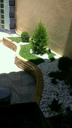 a small garden with rocks and plants in the center, next to a patio area