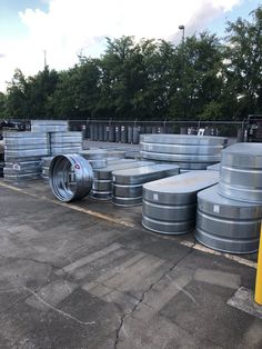 several metal barrels are lined up in a parking lot