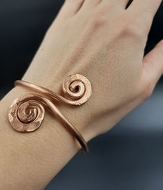 This is an adjustable, massive bracelet made of raw and pure copper.   Spiral diameter: 2 cm. It can be worn on the wrist or forearm. Adjustable circumference: 16-23 cm It can be made to order, any size. Wearing copper jewelry can leave greenish marks on the skin, that can be cleaned with soap and water. Wearing copper jewelry can stimulate healing, especially due to its ability to balance polarities or, in other words, the flow of projective and receptive energies. Nowadays, jewelry and ornamen Cooper Jewelry Handmade, Elegant Handmade Copper Bracelets, Handmade Spiral Copper Bracelets, Adjustable Spiral Copper Bracelet, Hammered Copper Jewelry, Adjustable Copper Spiritual Cuff Bracelet, 100% Copper Braclet, Handmade Copper Bracelet, Silversmith Jewellery