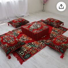 a group of red rugs sitting on top of a white floor