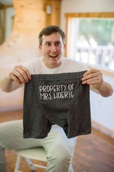 a man holding up a shirt that says property of mrs lorig