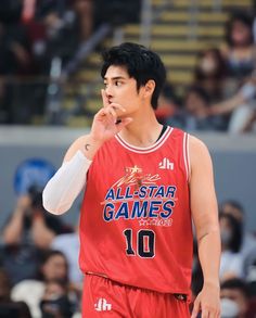 a basketball player is holding his hand up to his mouth