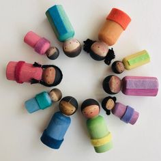 small wooden pegs arranged in a circle on top of a white surface, with different colors and shapes