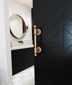 an open door leading to a bathroom with black and white tile