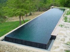 an empty pool in the middle of a grassy area