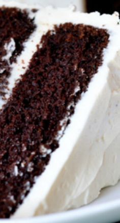 a slice of chocolate cake with white frosting on a plate