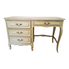 an antique white desk with drawers on it