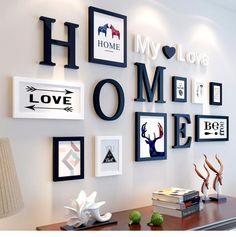 a white dresser topped with lots of pictures and framed art on the wall next to a lamp