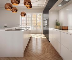 a modern kitchen with wooden floors and white cabinets, lights hanging from the ceiling over the island