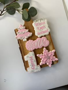 decorated cookies are displayed on a wooden board