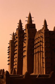 an intricately designed building in the middle of desert with lots of spikes sticking out of it's sides