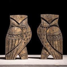 two carved wooden owls sitting next to each other