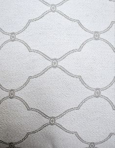 an upholstered white fabric with silver circles and lines on the back of it