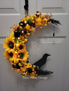 a wreath with sunflowers and black birds hanging on the side of a door