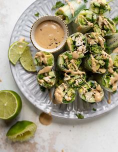 a plate filled with broccoli wrapped in cucumber and topped with sauce