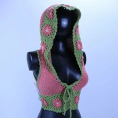 a mannequin wearing a pink and green crocheted hood with flowers on it