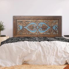 a bed with white linens and a wooden headboard on it's side