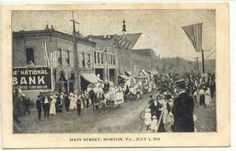 an old postcard shows people walking down the street in front of bank buildings and flags