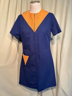 This is a cute vintage dress from the 70s.  The label is an image of a butterfly. Tagged a size 14. The bust measures 38", waist 35", hip 39", see measurements below.  Made of a polyester in navy blue with orange accents. It is a shift style dress. It is short sleeve.  Orange yoke in front & on the pocket. About knee length. Zips in the front with a nylon zipper.  The dress is in good vintage condition. There is a spot of broken stitches next to the zipper on the orange yoke. No other damage.  No soil or stains.   Cute!  Measurements were taken with the garment lying flat and without stretching. If you have never worn vintage before, please measure yourself or a similar garment that fits you well & compare the measurements to these.  Vintage sizes run smaller than today's sizes, you need t Retro Blue Knee-length Vintage Dress, Blue Fitted Retro Vintage Dress, Lined Retro Vintage Dress, Blue Retro Vintage Dress With Short Sleeves, Retro Blue Vintage Dress With Short Sleeves, Vintage Blue Dresses With Pockets, Blue Vintage Dresses With Pockets, Retro Fitted Dress With Pockets, Short Sleeve Shift Dress