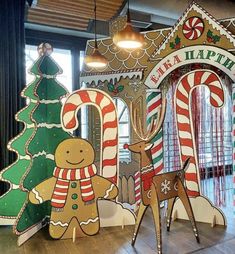 christmas decorations are on display at the entrance to a building that is decorated with gingerbreads and candy canes