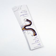 a wedding card with a snake design on the front and back side, sitting on top of a white table