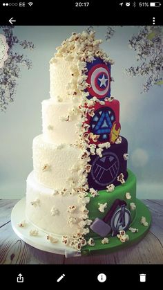 a three tiered wedding cake with captain america and avengers decorations on the top layer