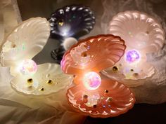 three flower shaped lights sitting on top of a white cloth