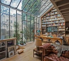 a living room filled with lots of furniture and bookshelves next to a window