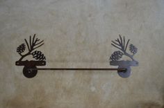 two wrought iron pinecone hooks hang on the wall next to a towel bar