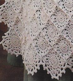 there is a crocheted shawl on display in the window sill, and it looks like something out of an old book